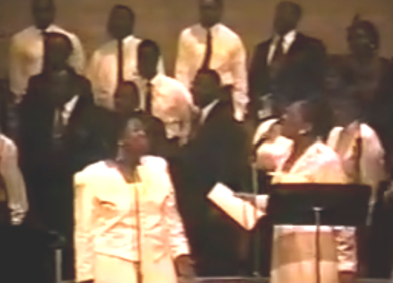 Order My Steps - ORiginal Video with Barbara Tucker standing in front of a choir next to Bettye Nelson on stage, wearing white dresses.