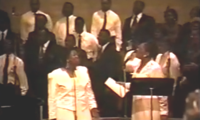 Order My Steps - ORiginal Video with Barbara Tucker standing in front of a choir next to Bettye Nelson on stage, wearing white dresses.